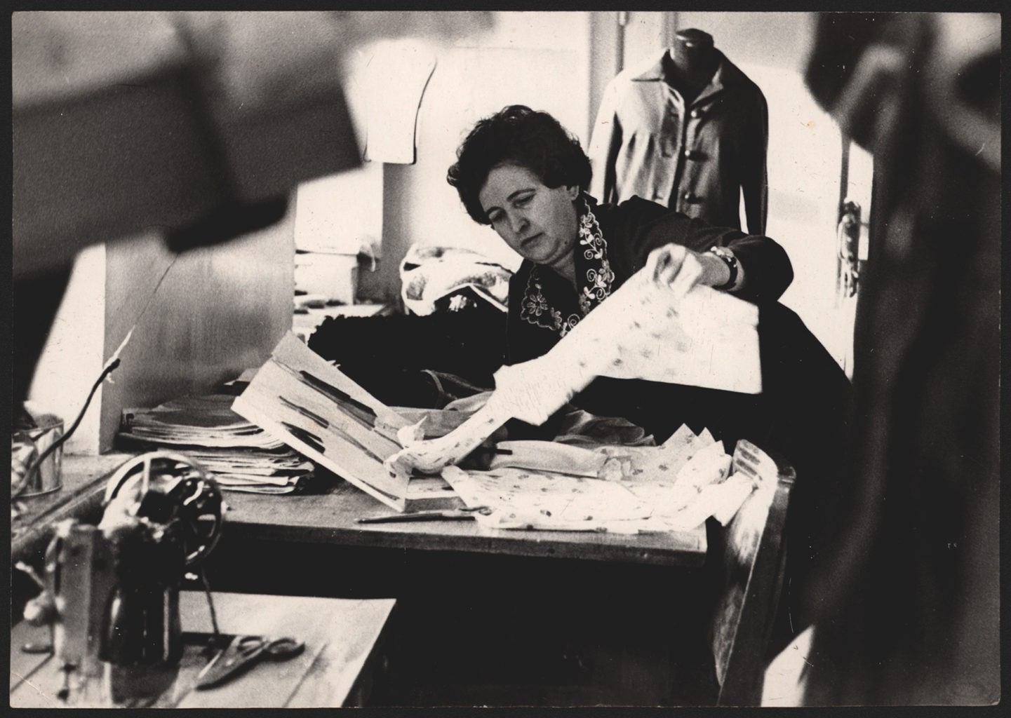 М. Сударева (зав. костюмерным цехом Прокопьевского драматического театра) подбирает ткань для костюма, 1980-е г.: фотография